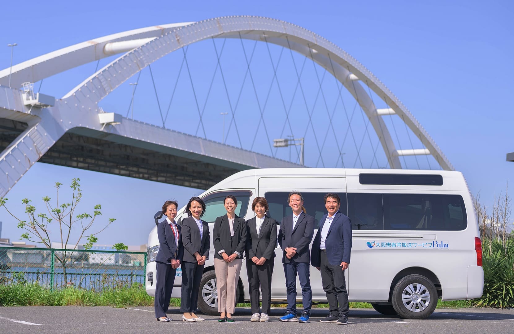 送迎車の前に立つReTabyのスタッフ